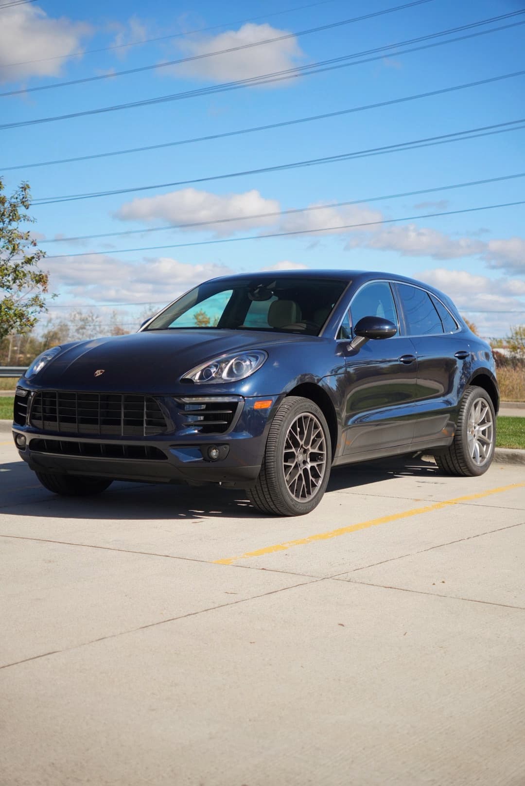 Dark blue Porsche Macan, front three-quarter, in a parking lot