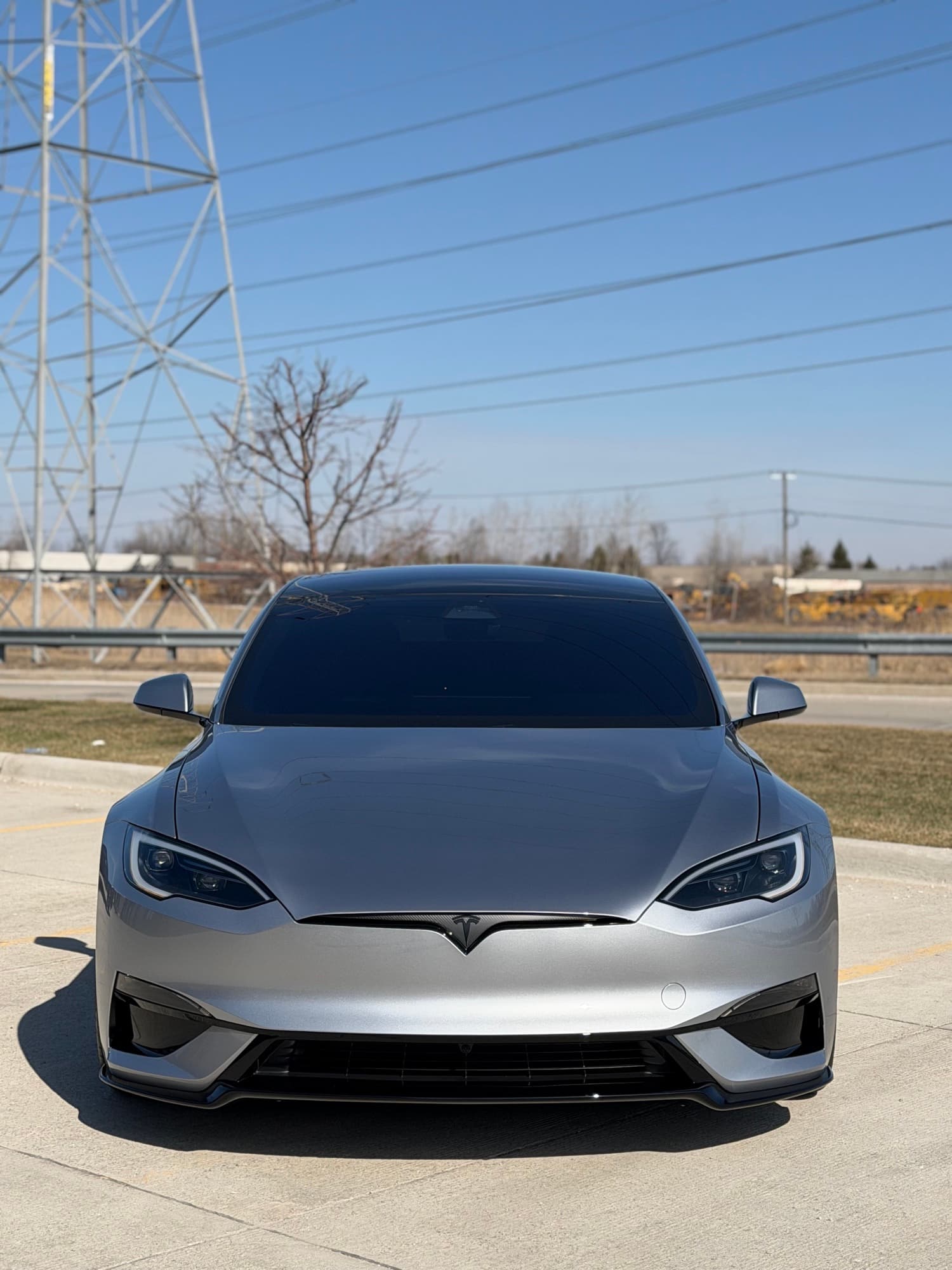 Silver Tesla Model S Plaid with dark tinted glass, head-on, outdoors